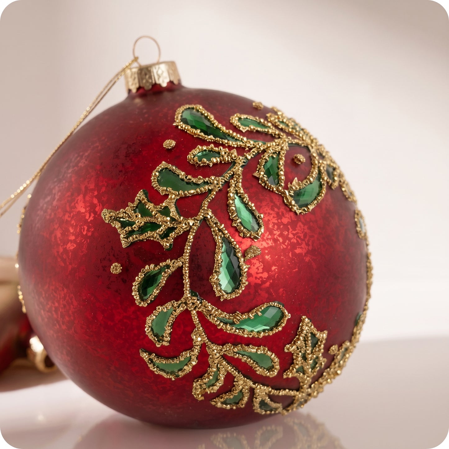 Esfera de cristal rojo con hojas verdes y brillos dorados 12 cm