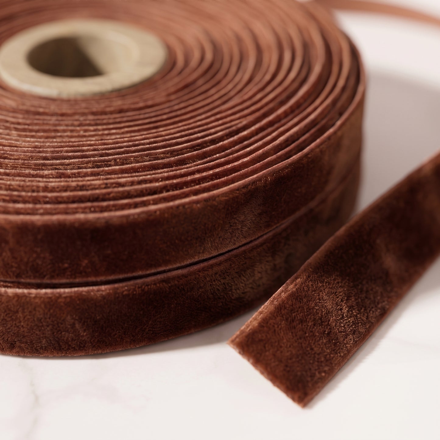 Liston de terciopelo sobre carrete de madera marrón chocolate