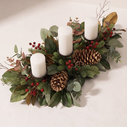 Centro de mesa con piñas, hojas de magnolia y porta velas