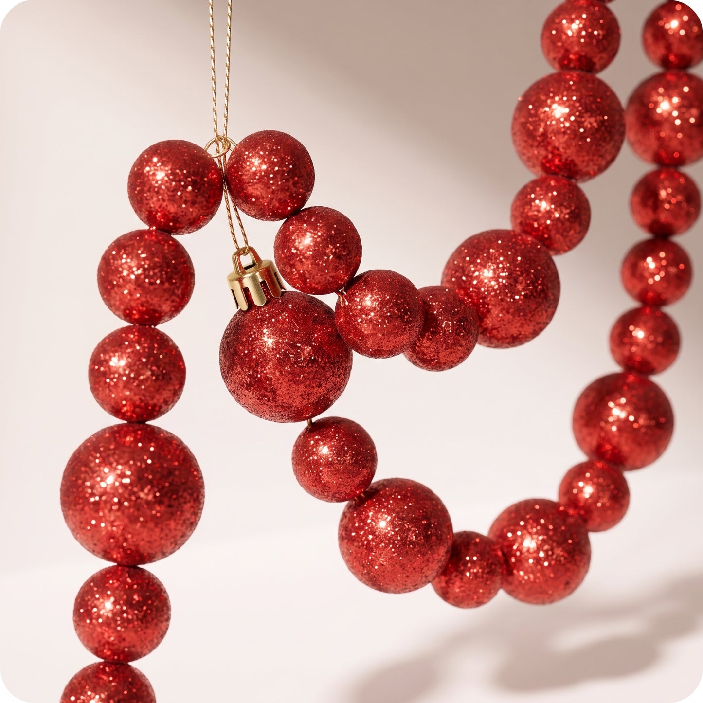 Guirnalda roja con brillos y esferas grandes y pequeñas