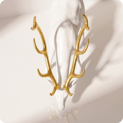 Reno decorativo dorado de resina blanco con cuernos dorados agachado