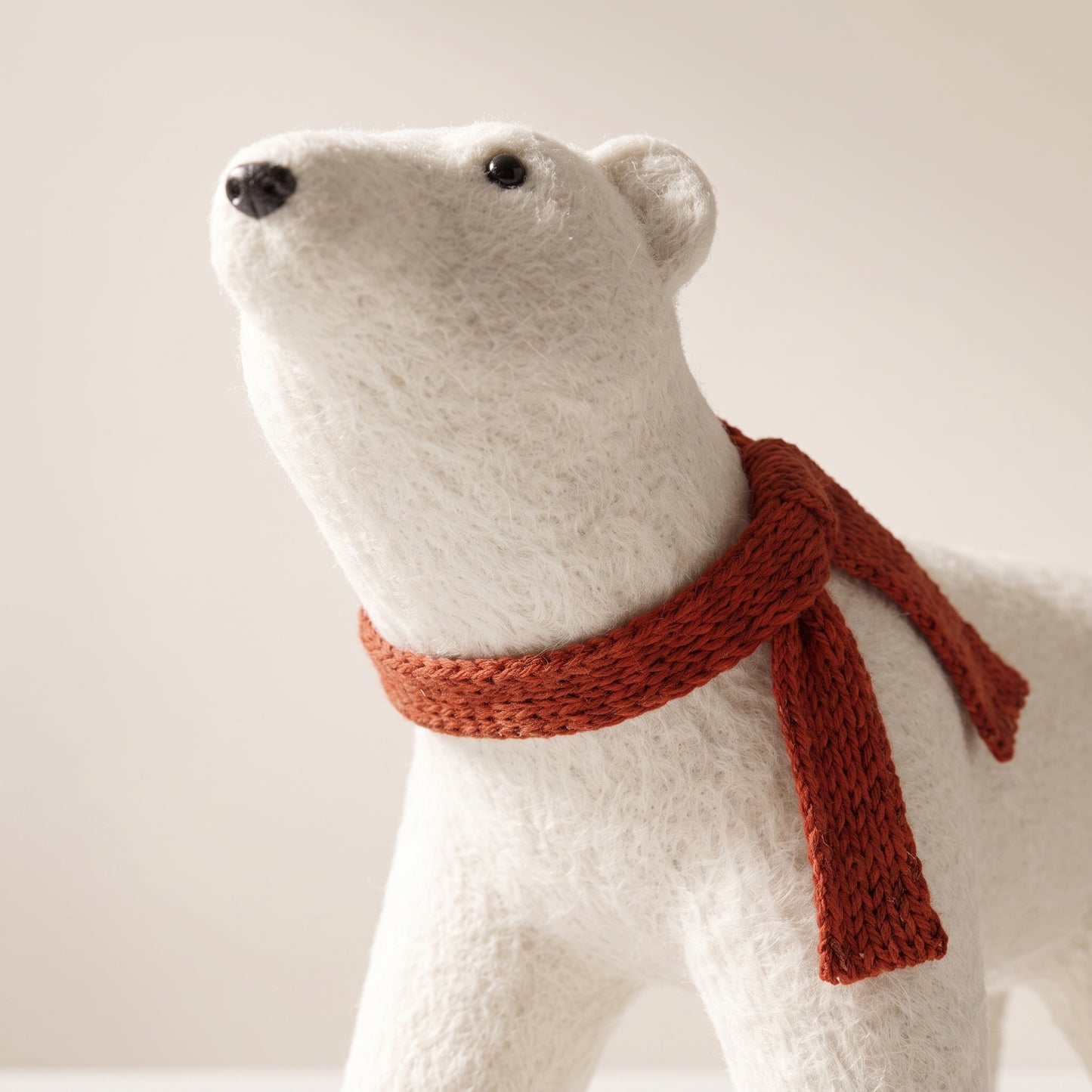 Elegante oso polar blanco con bufanda roja en cuatro patas 1