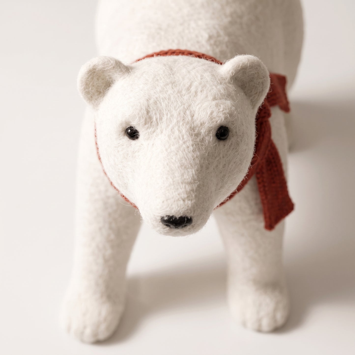Elegante oso polar blanco con bufanda roja en cuatro patas 1