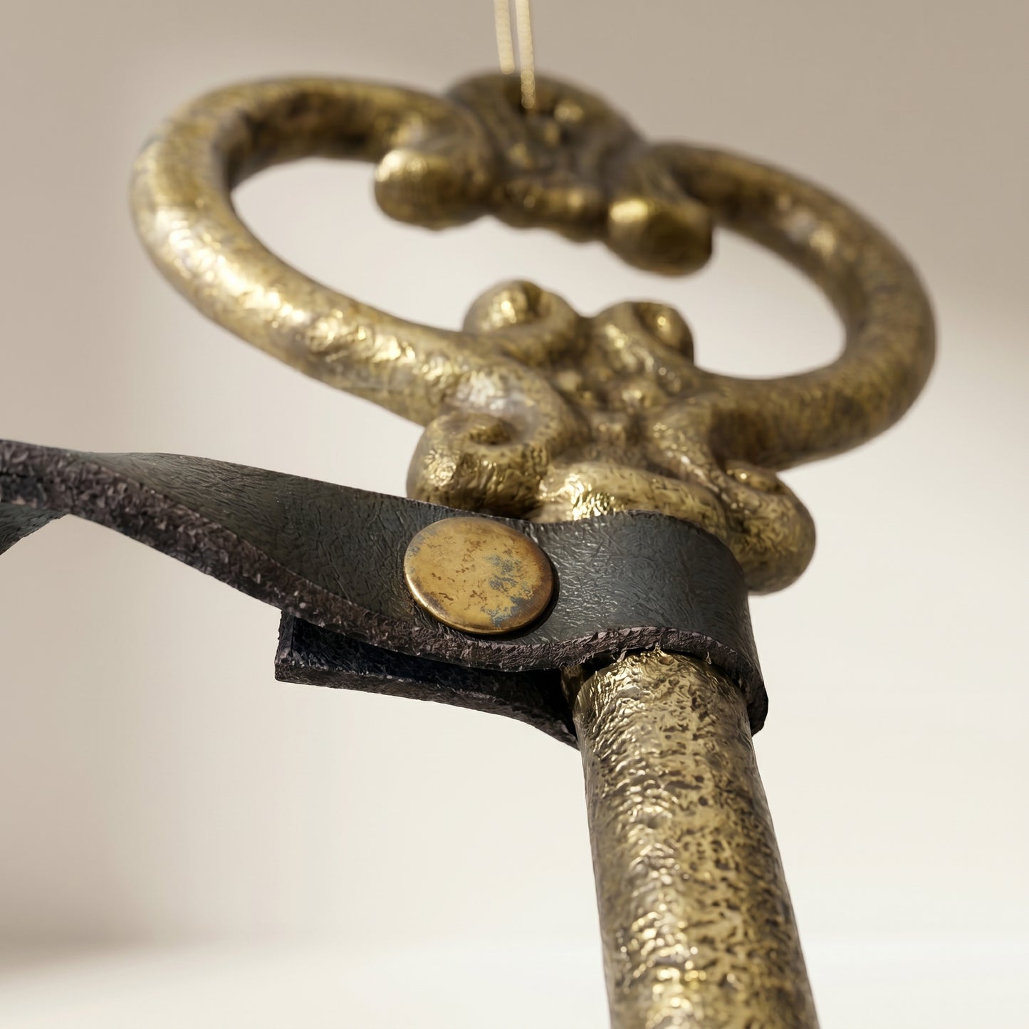 Adorno de llave antigua con correa de cuero dorada