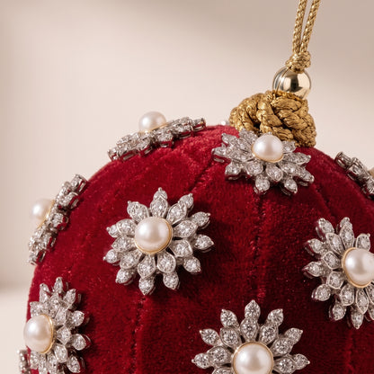 Esfera de terciopelo rojo con perlas blancas al rededor
